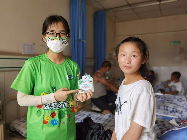 好來(lái)志愿者給孩子們講解并贈(zèng)送口腔小冊(cè)子